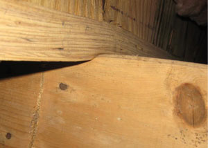A failing girder showing signs of compression damage in a California home